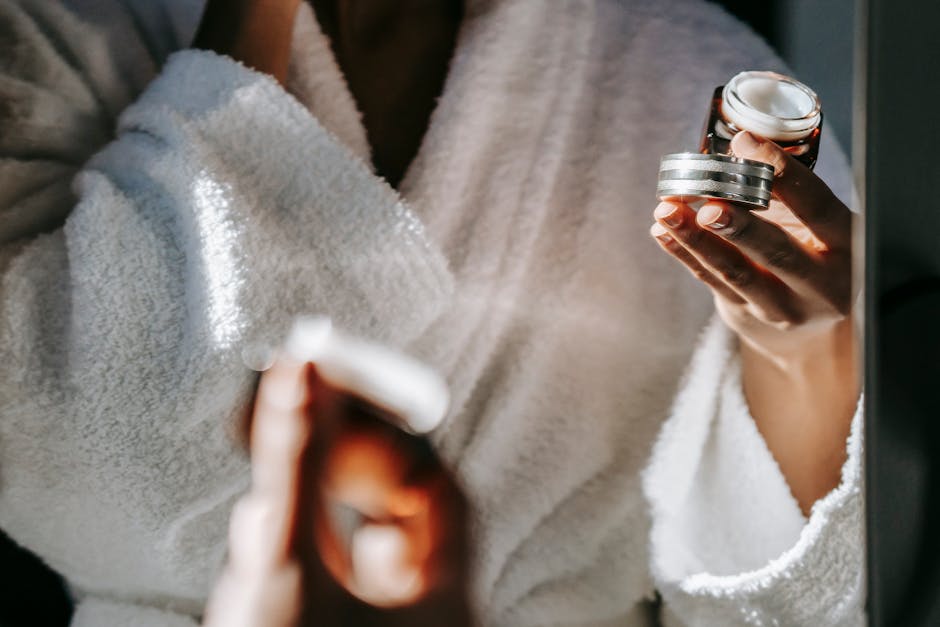 Woman in bathrobe applying skincare cream for a calm morning routine